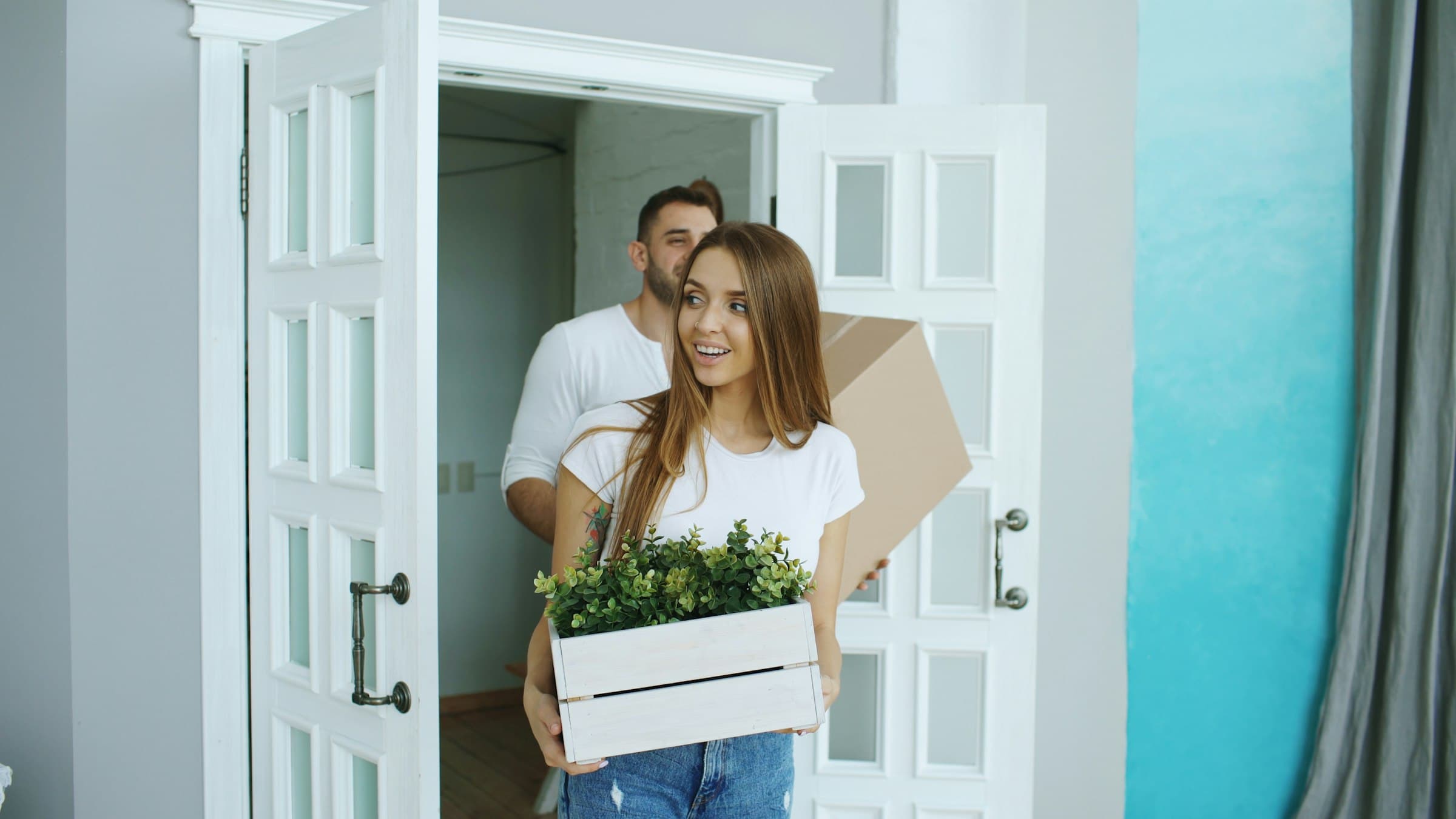 Paar betritt mit Umzugskartons das neue Zuhause